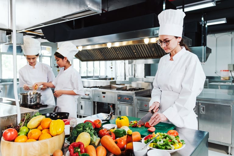 Chef slicing fresh tomatoes in professional kitchen